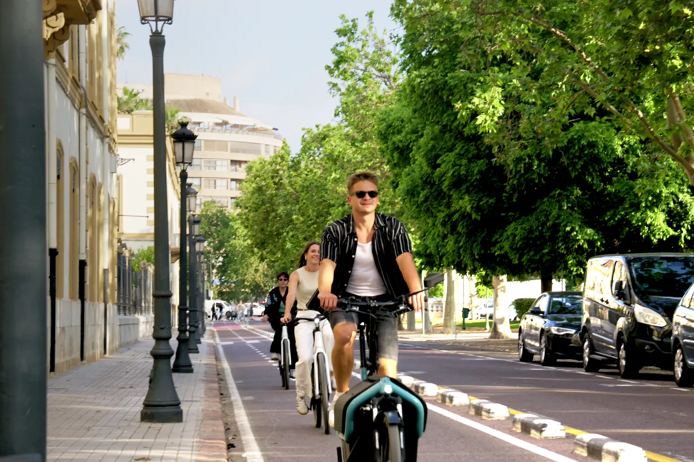 Tres personas pedaleando por el carril bici de Valencia con e-bikes de Clover